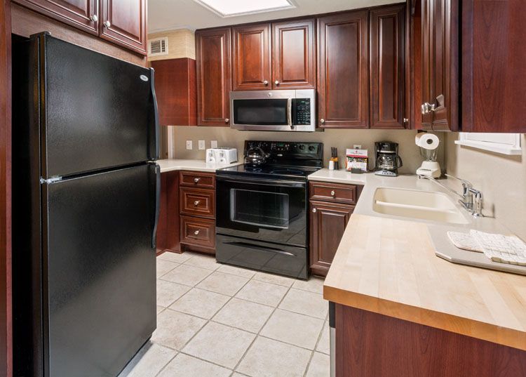 a kitchen with black appliances and wooden cabinets