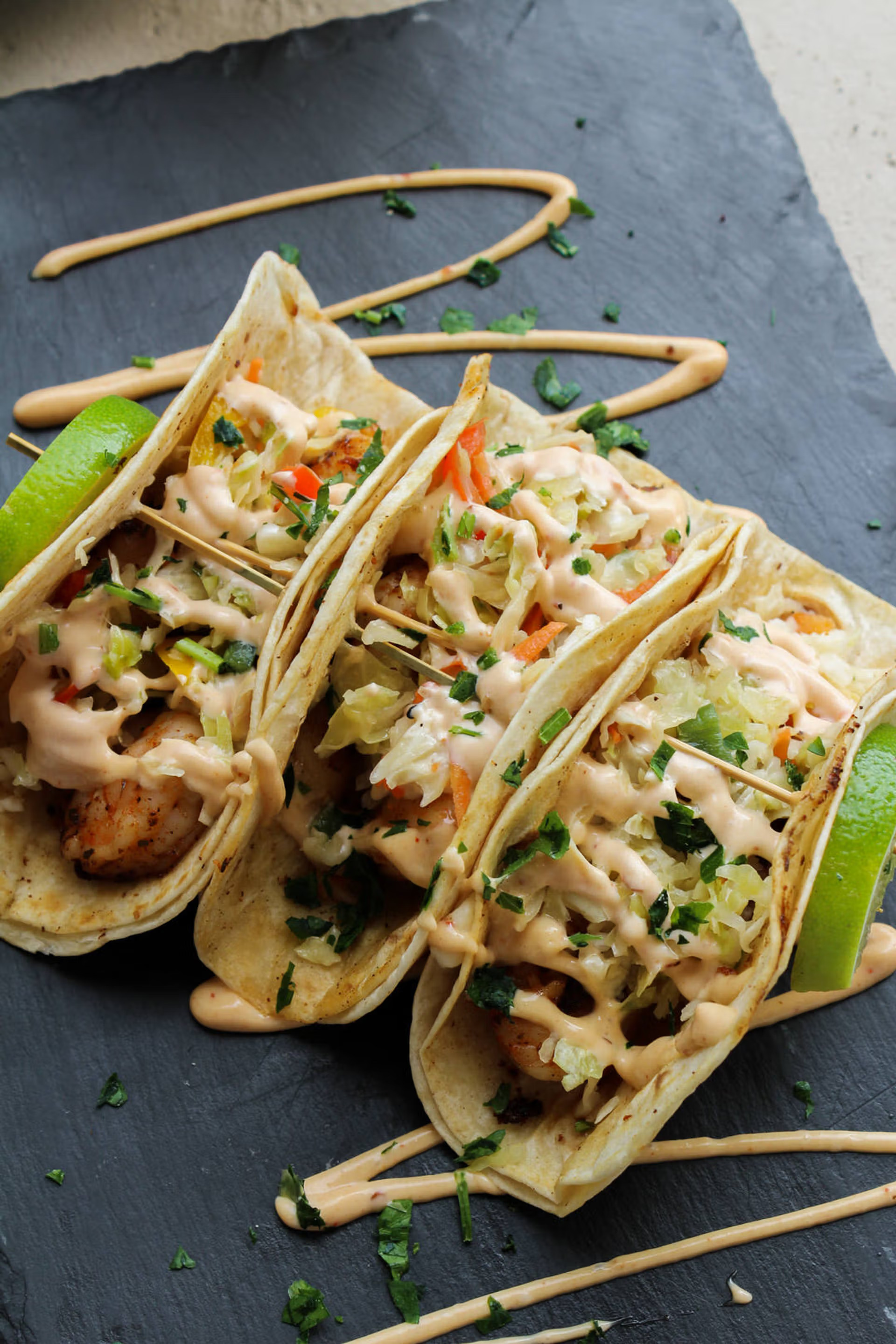 a group of tacos on a black plate