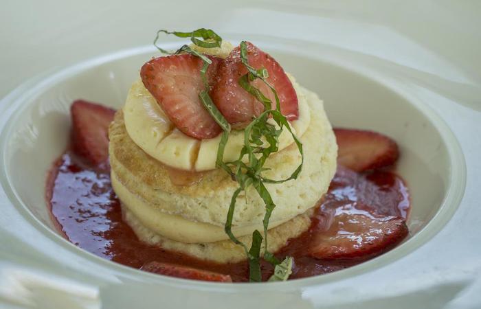 a plate of food with strawberries and a sauce