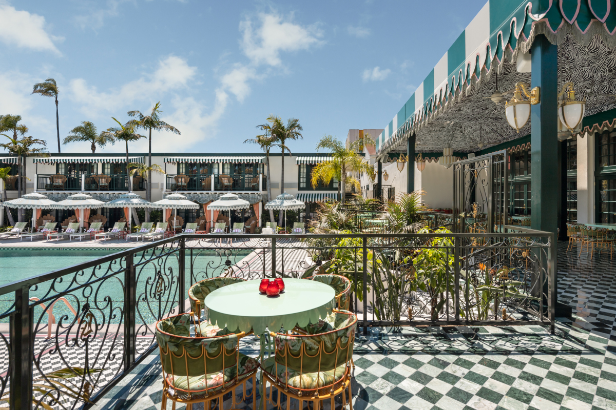 a table and chairs on a patio with a pool in the background