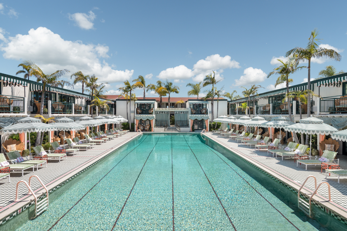 a swimming pool with lounge chairs and umbrellas