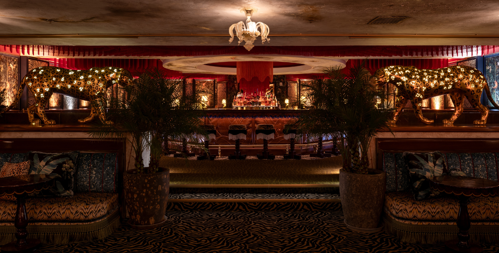 a room with a bar and a chandelier