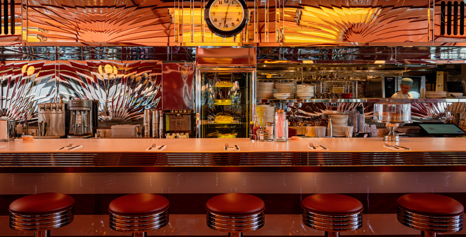 a counter with a clock and shelves in front of it