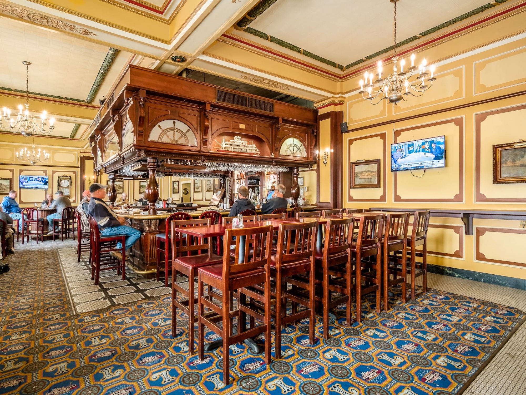 a room with a bar and people sitting at tables