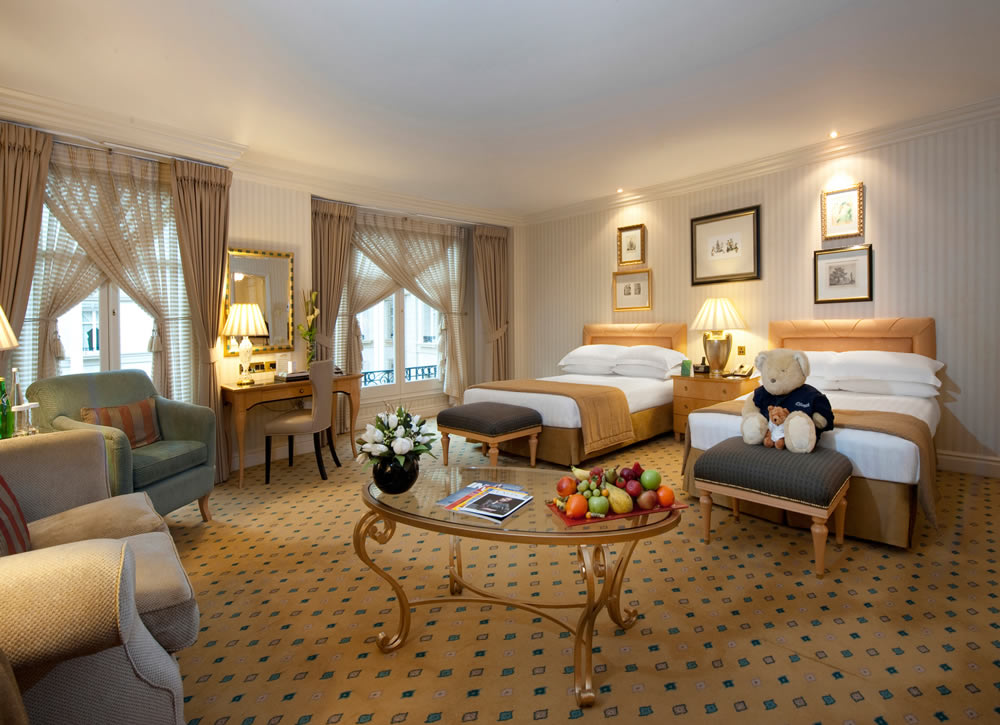 a room with a teddy bear and a table with fruit