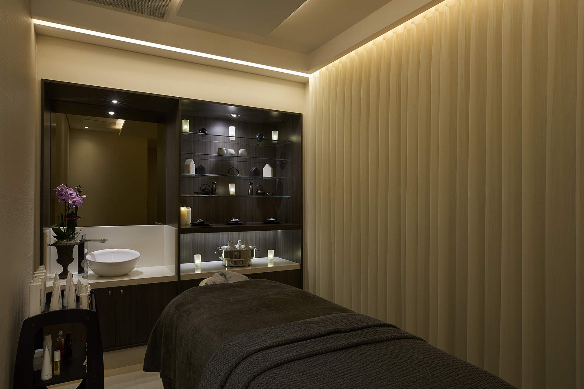 a massage room with a mirror and a sink