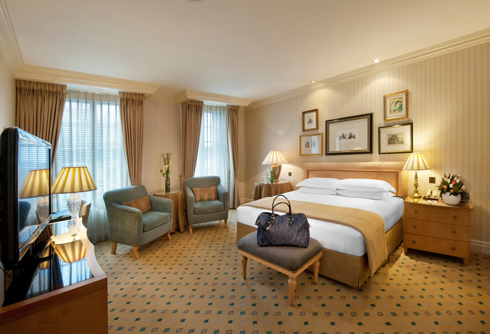 a room with a bed and chairs