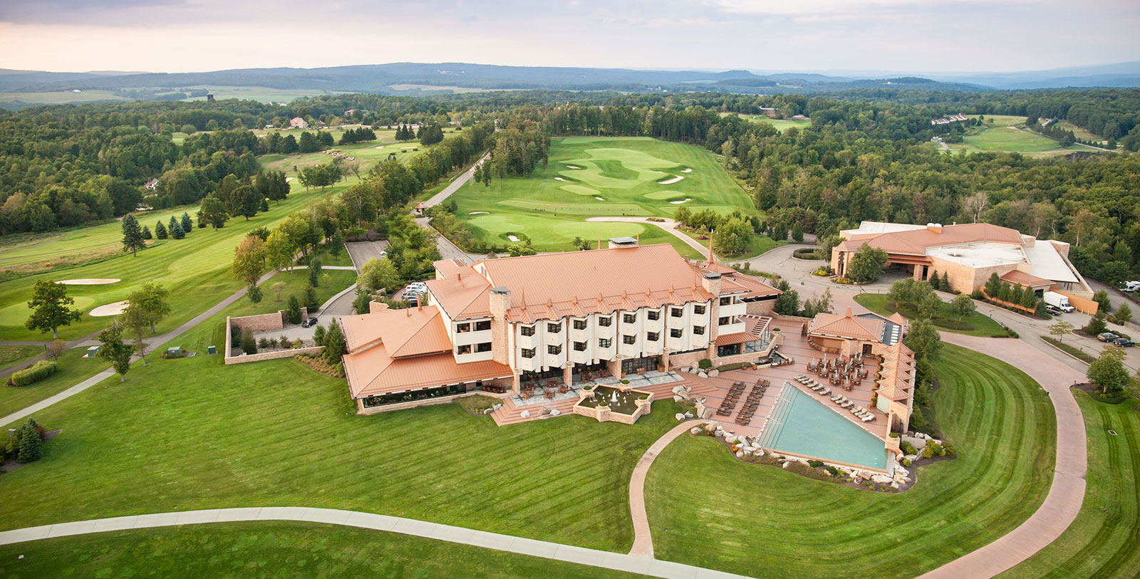 a large building with a pool and golf course