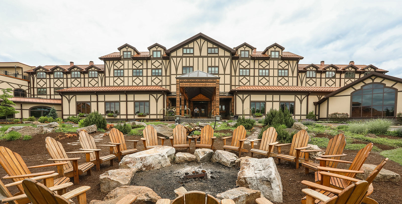 a large building with a fire pit and chairs