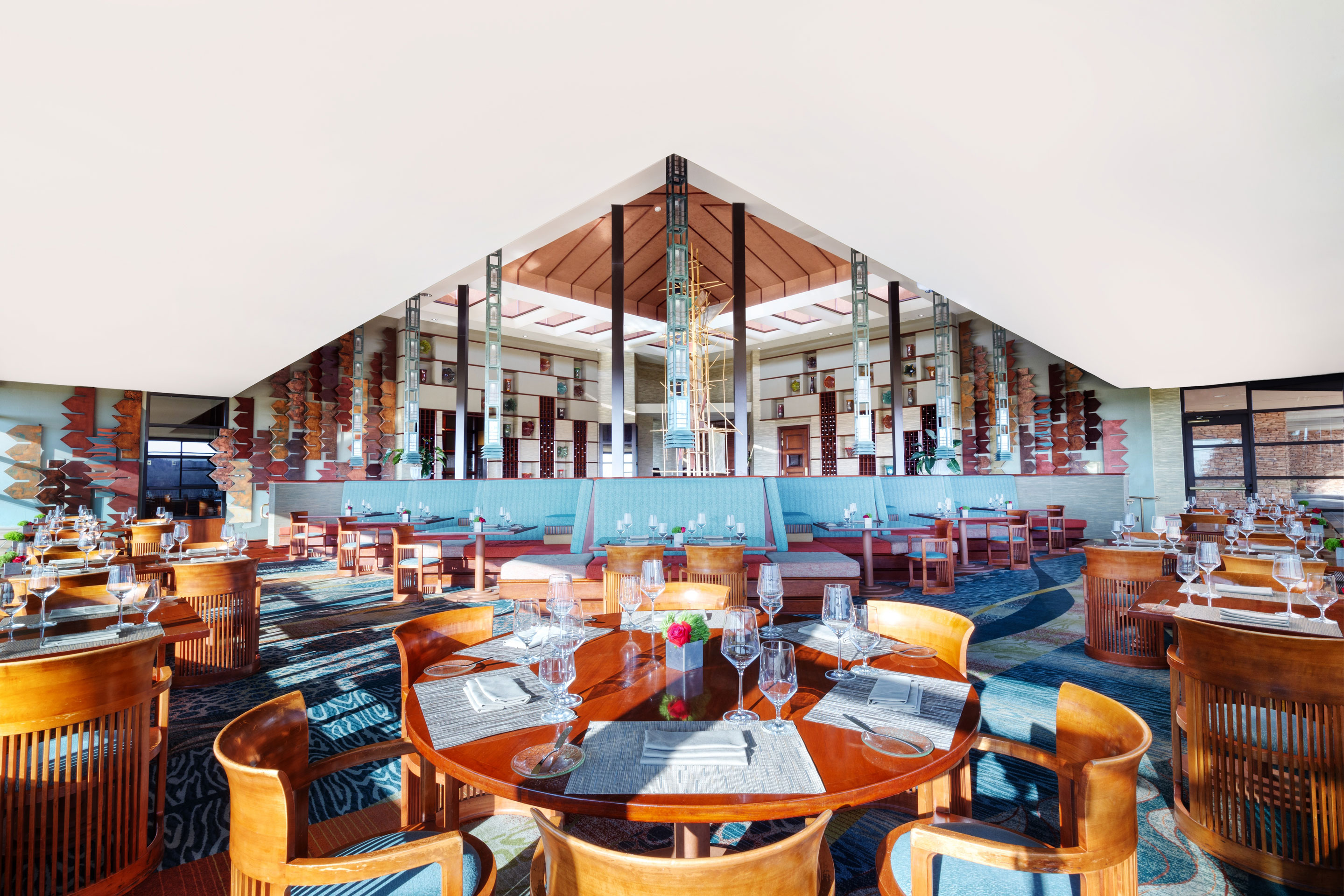a room with a triangular ceiling and tables and chairs