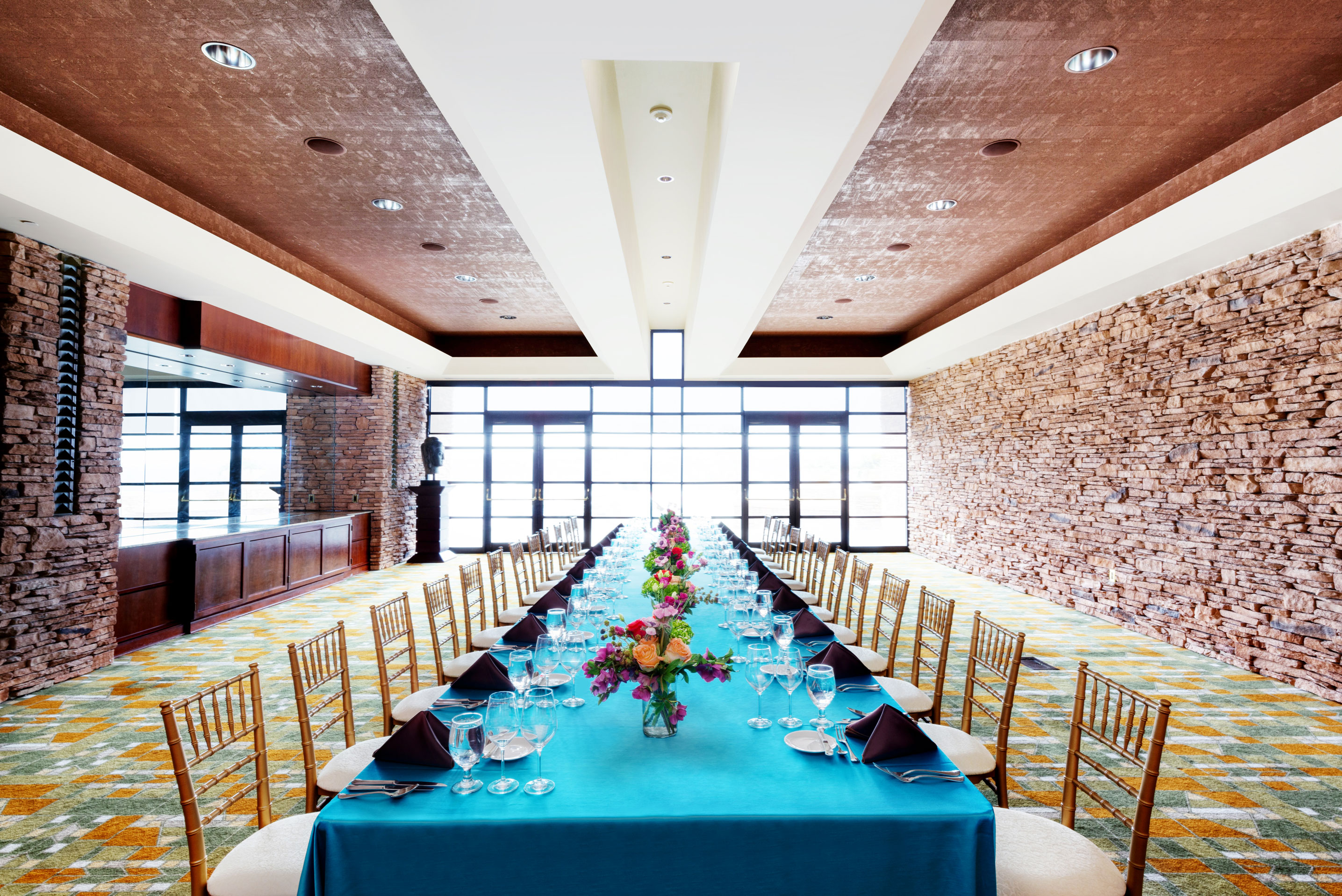 a long table with blue tablecloths and flowers on it
