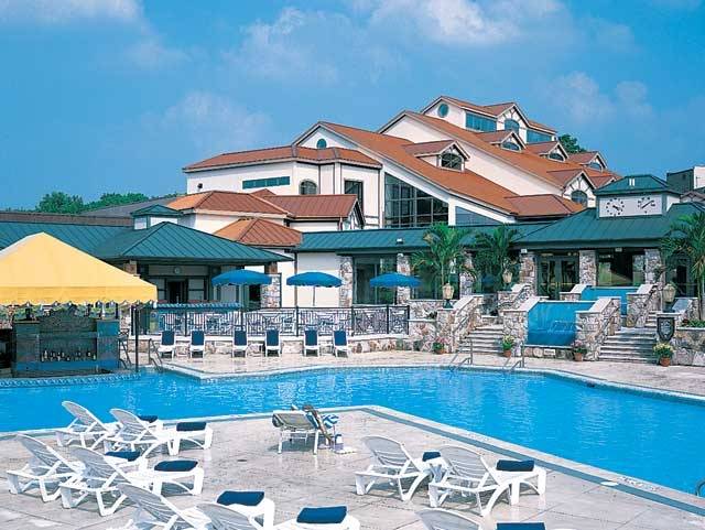 a swimming pool with chairs and umbrellas