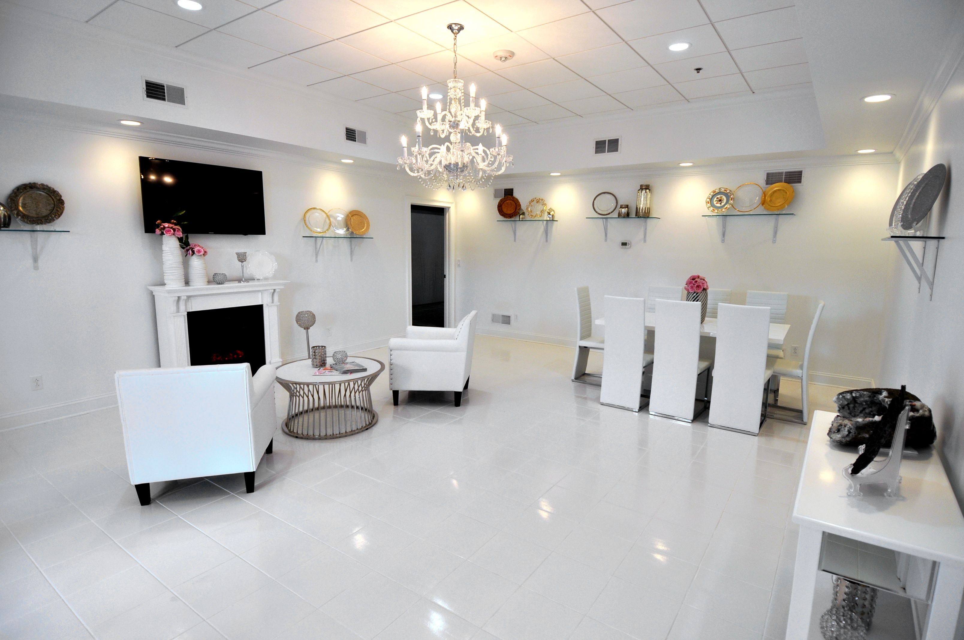 a room with white furniture and a chandelier