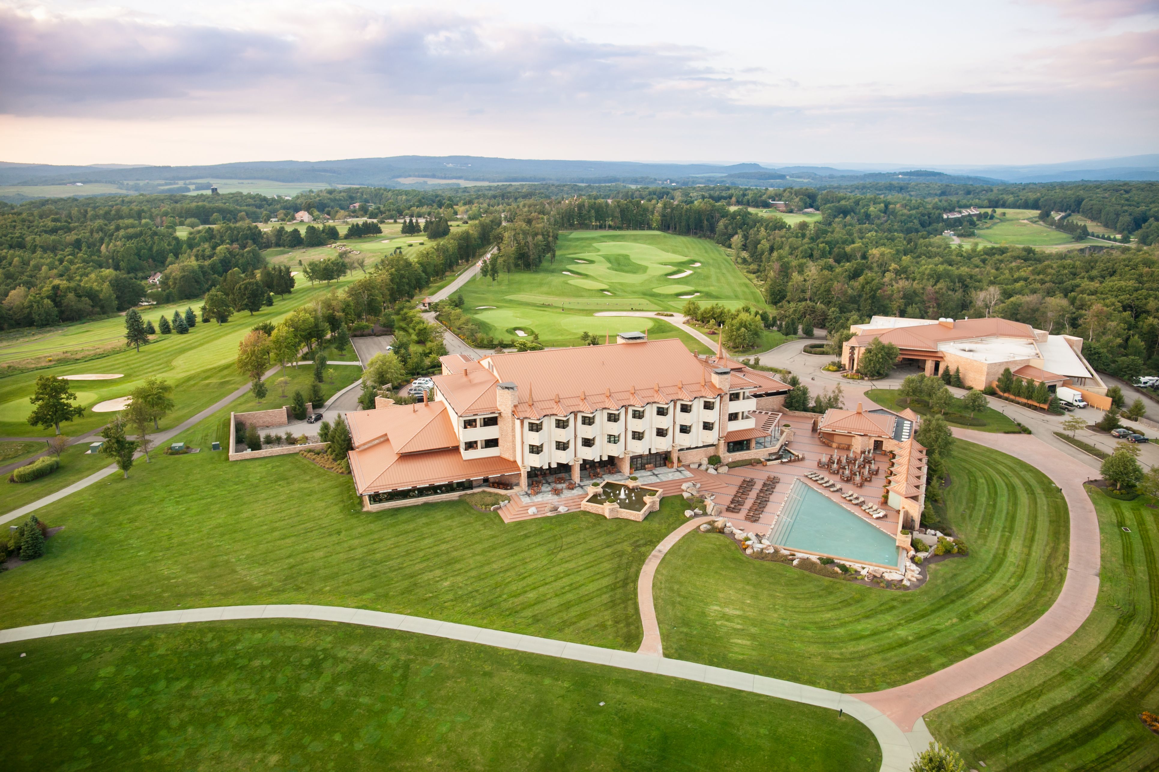 a large building with a pool and a golf course