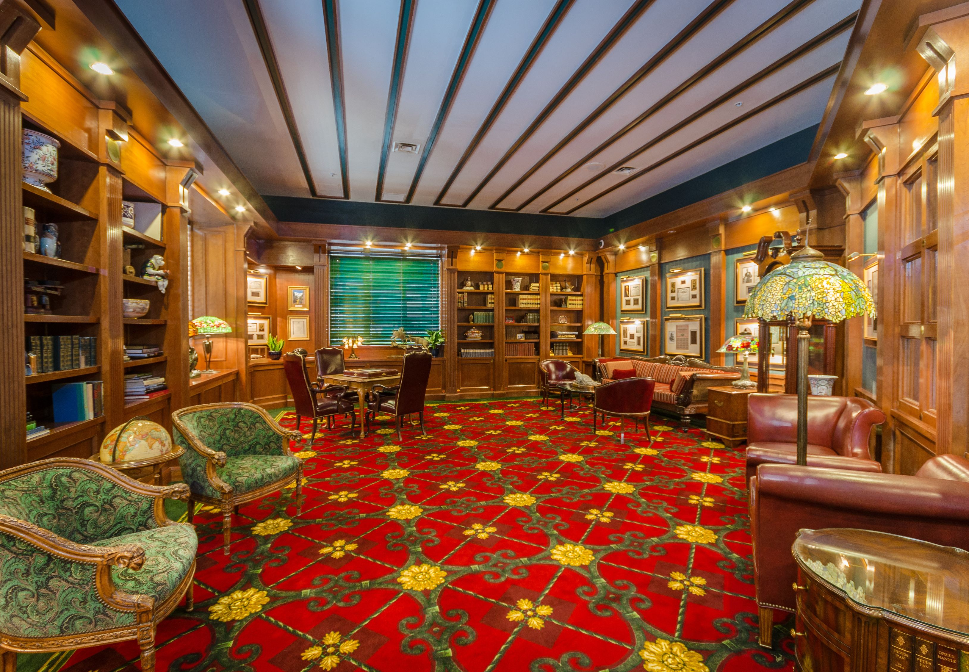 a room with a red carpet and chairs