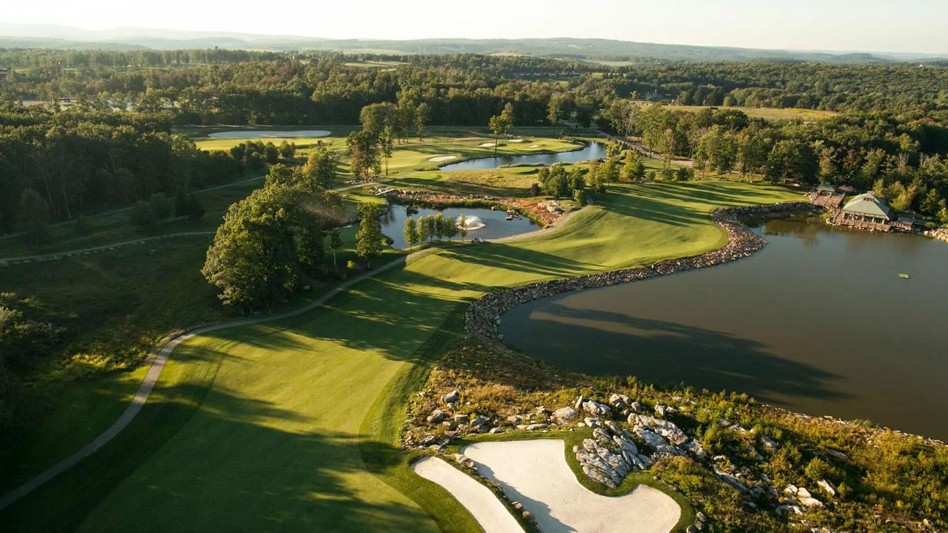 a golf course with water and trees