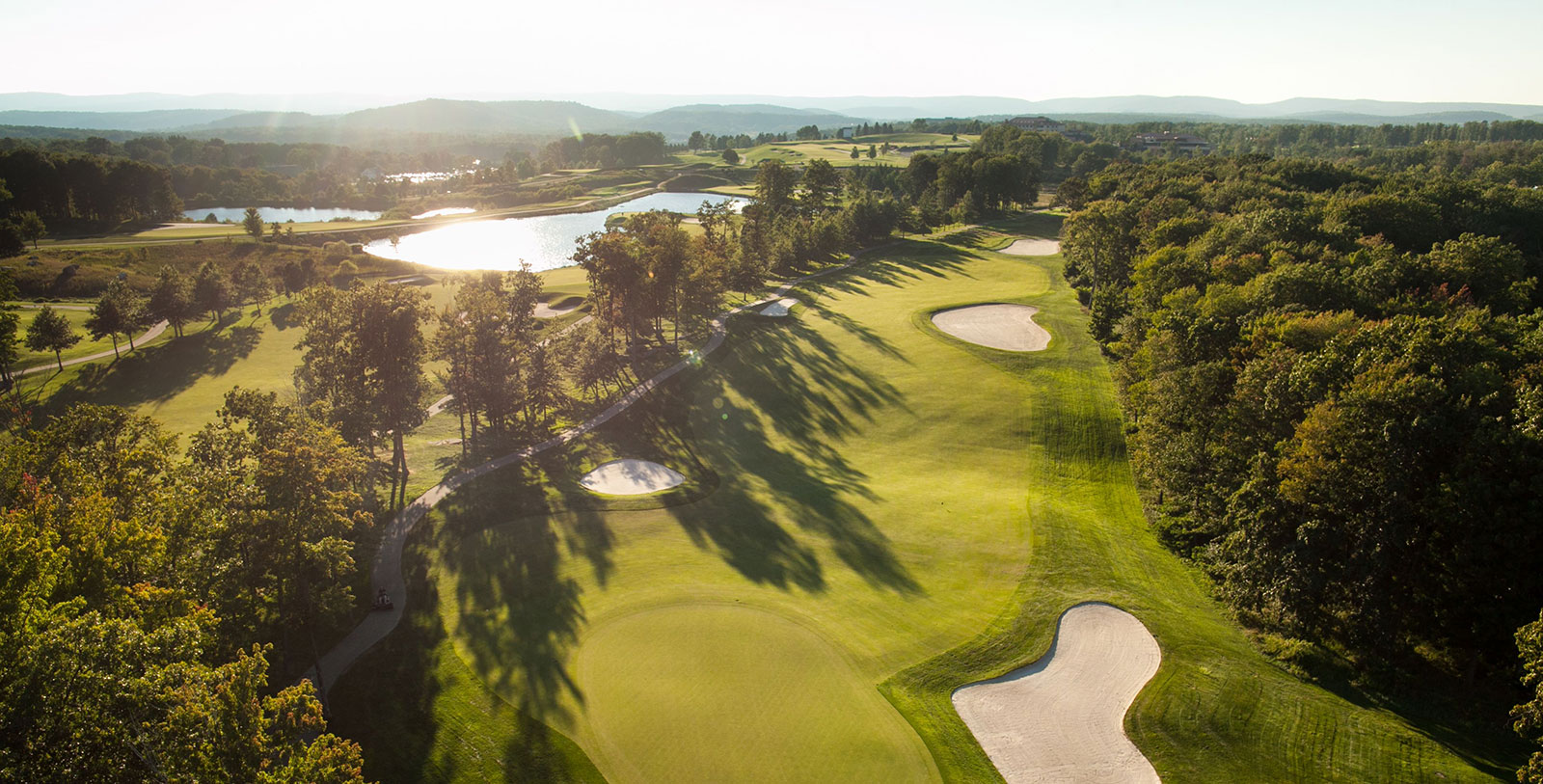 a golf course with sand bunkers and water