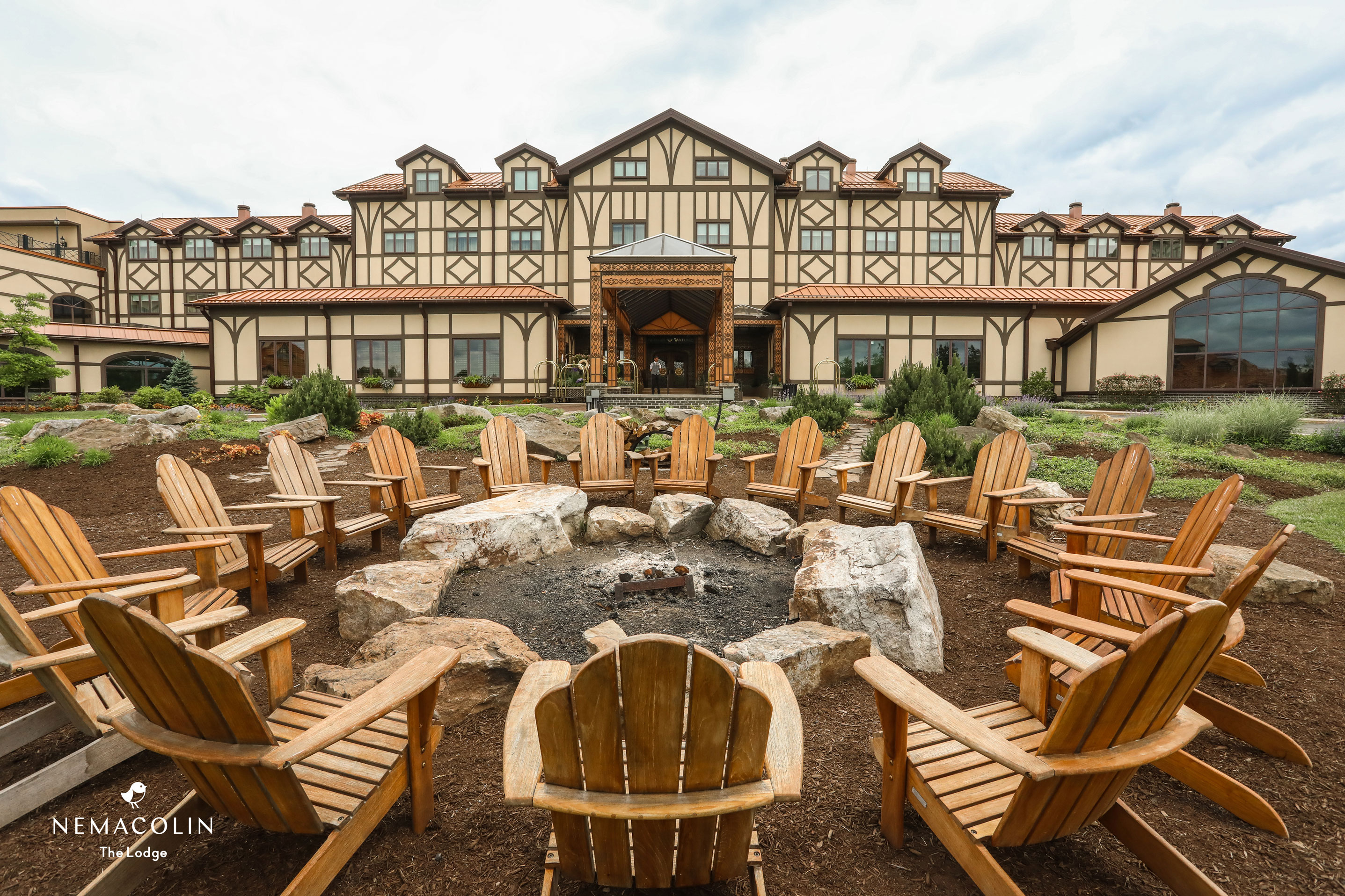 a large building with a fire pit and chairs