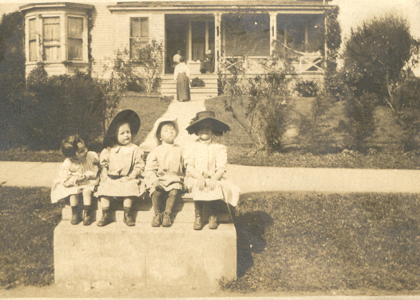 a group of children sitting on a ledge