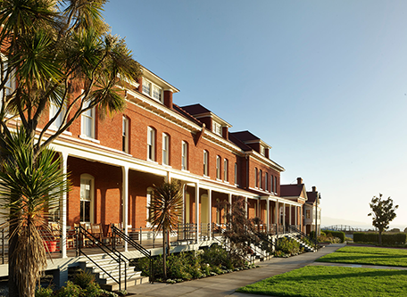 a row of brick buildings with stairs and grass