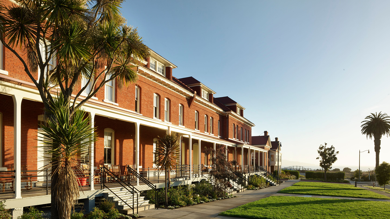 a row of brick buildings with green lawns and grass