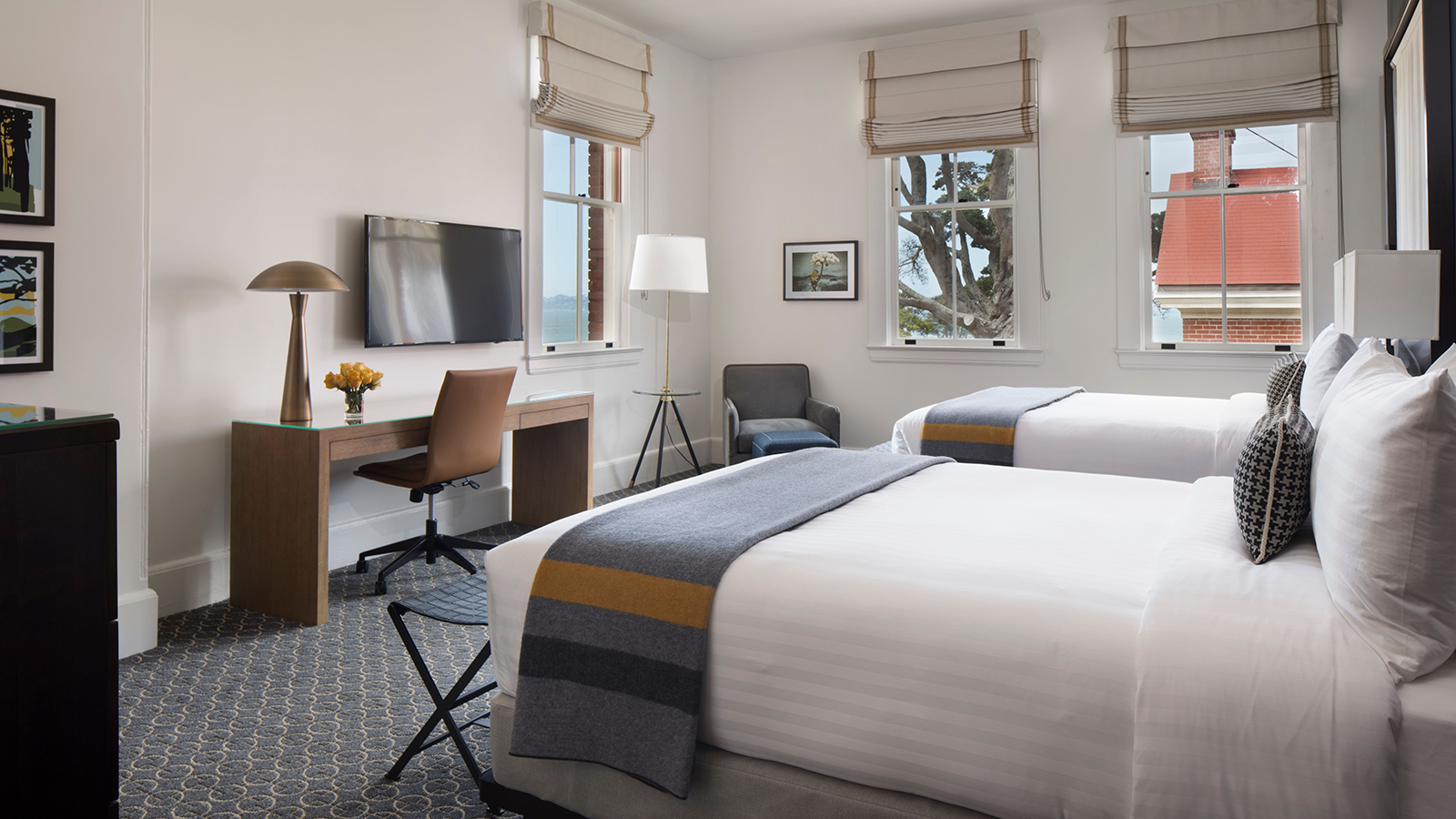 a room with two beds and a desk and a tv