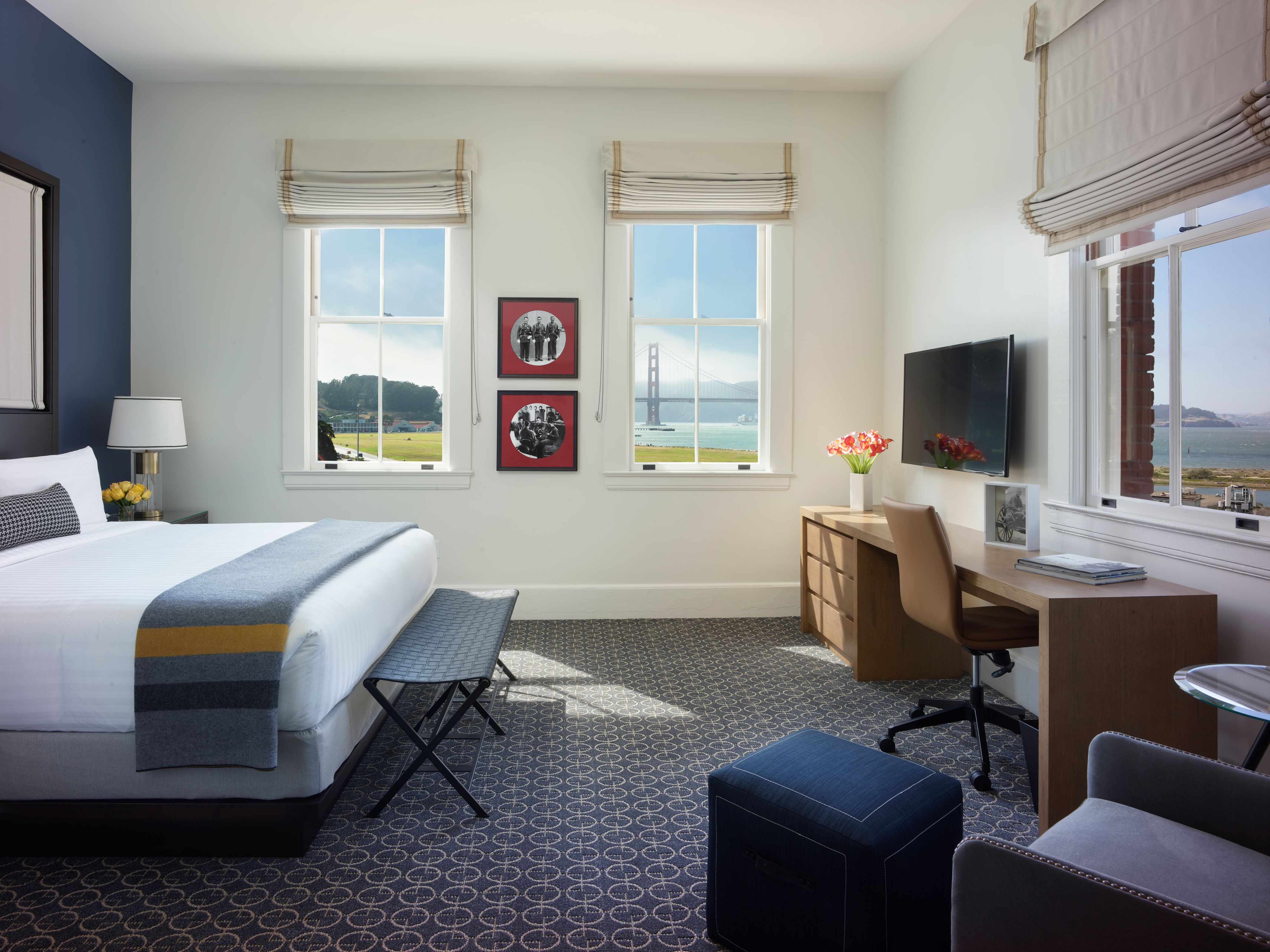 a room with a bed and a desk and a television