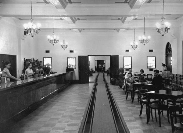 a group of people sitting at tables in a restaurant