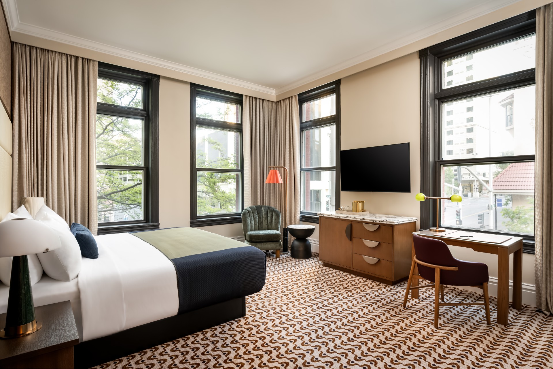 a room with a bed and a chair and a television