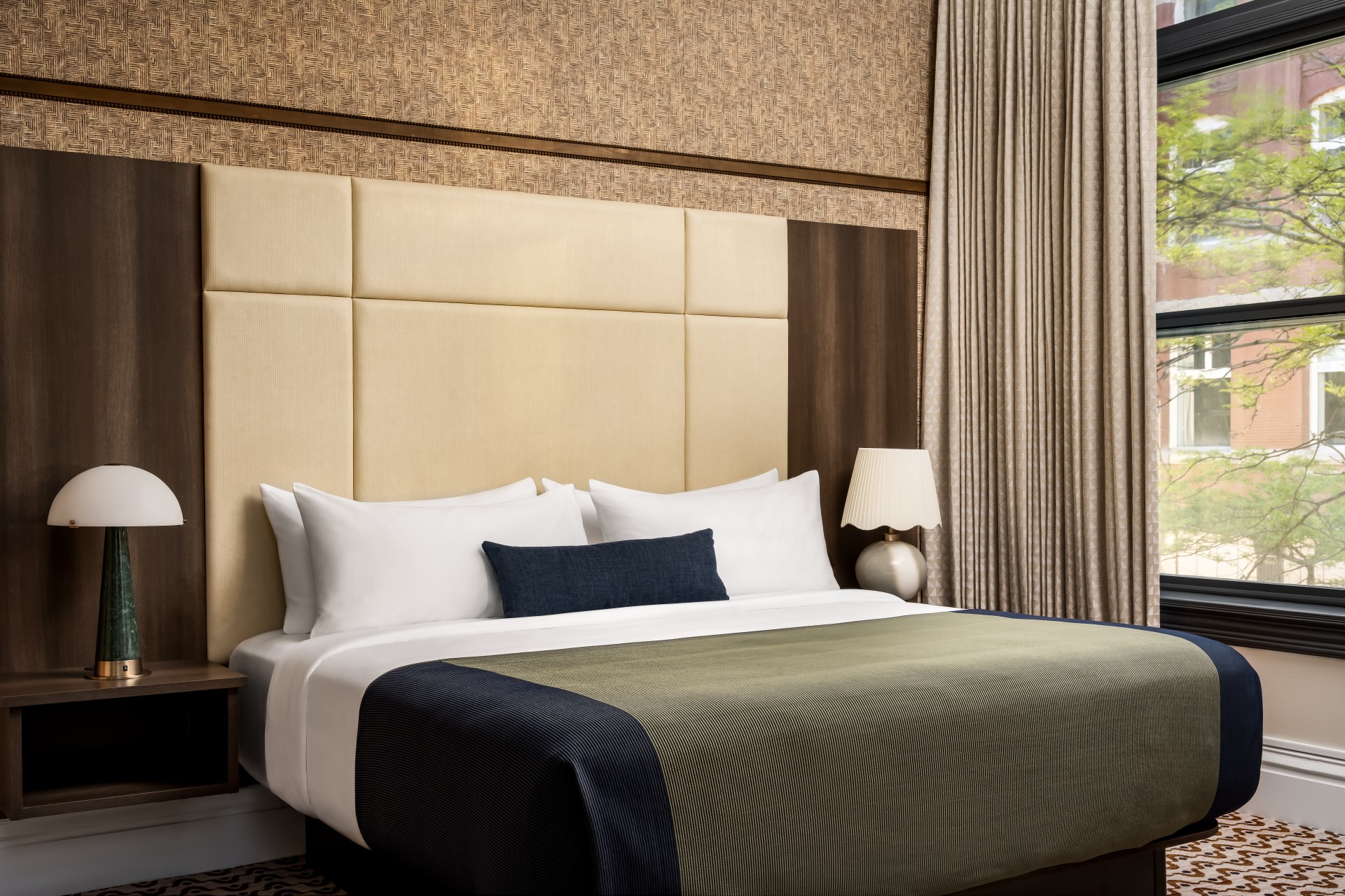a bed with a headboard and a lamp