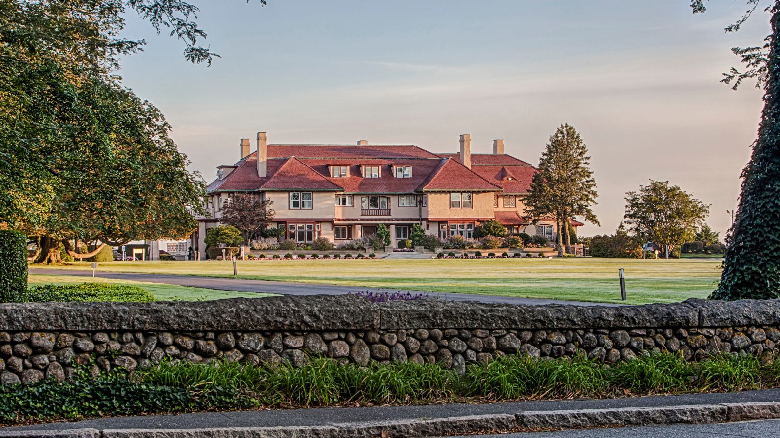 a large house with a lawn and grass field
