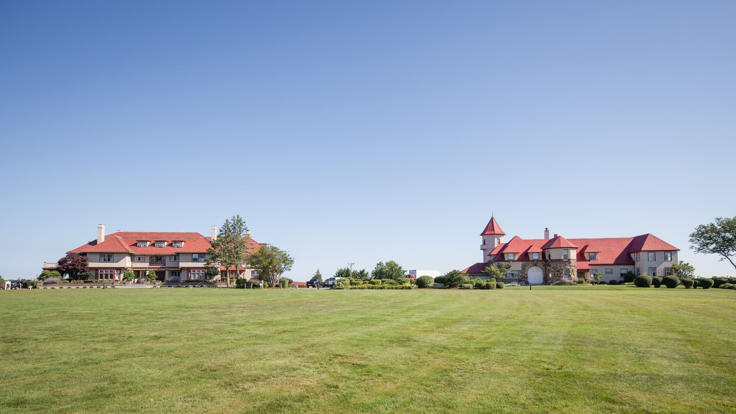 a large lawn with houses in the background