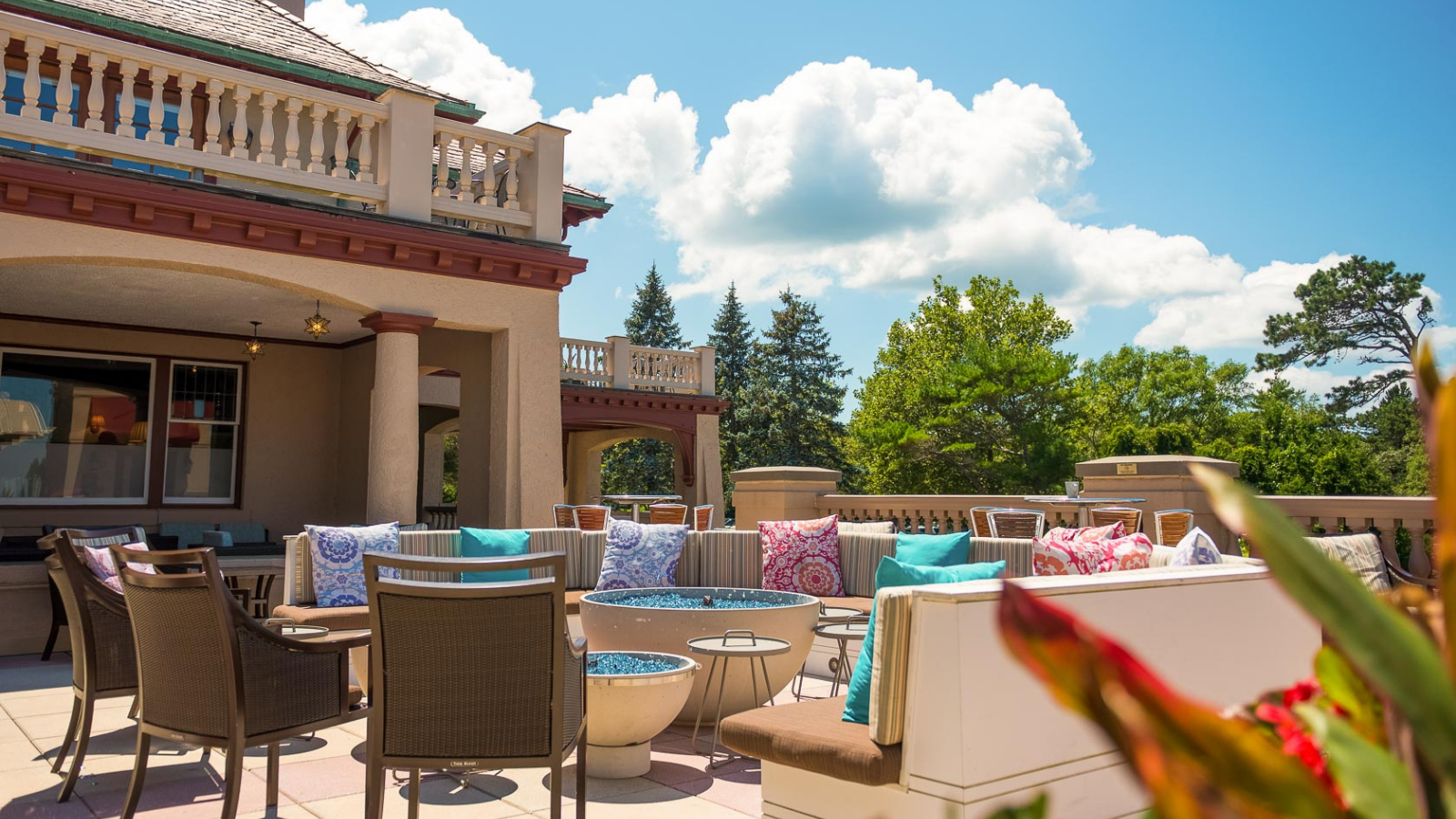 a patio with chairs and tables on a sunny day