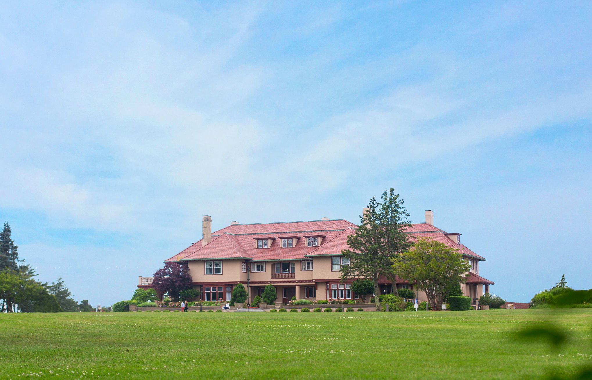 a large house with a lawn and trees