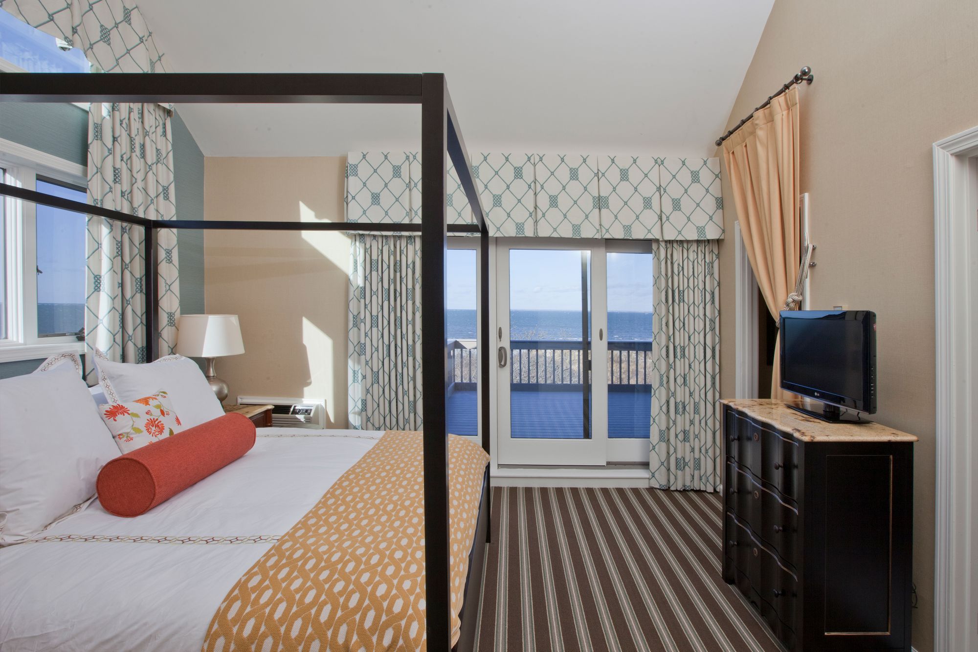 a bedroom with a large glass canopy bed and a television