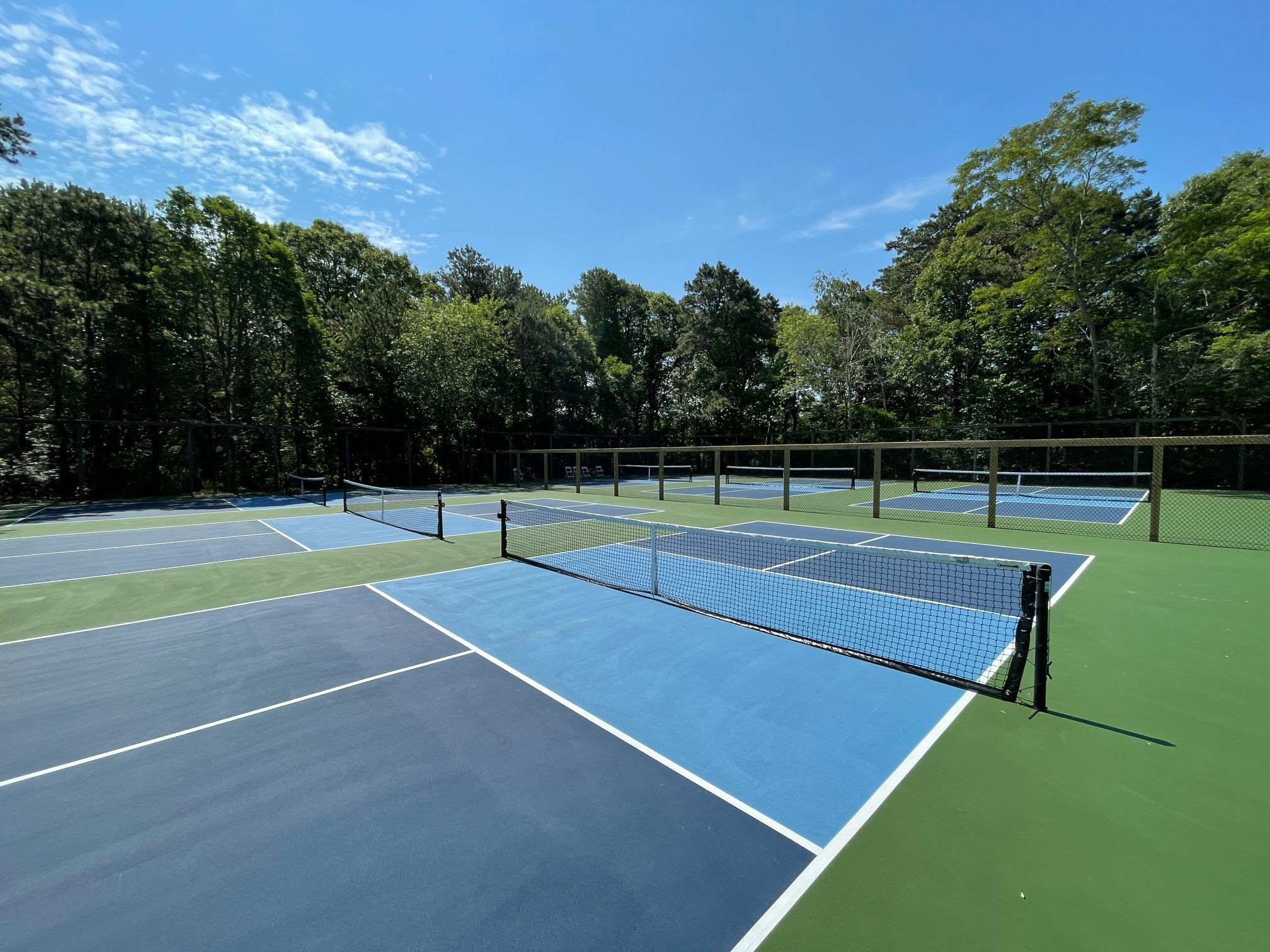a tennis court with net and trees in the background