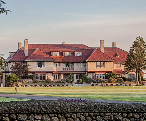 a large building with a lawn and trees