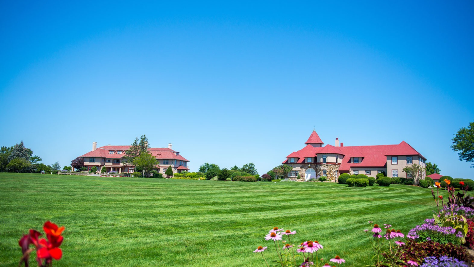a large lawn with a house and flowers
