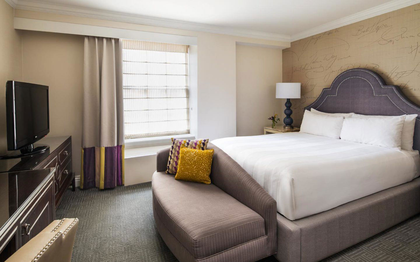 a bed with a couch and a lamp in a hotel room