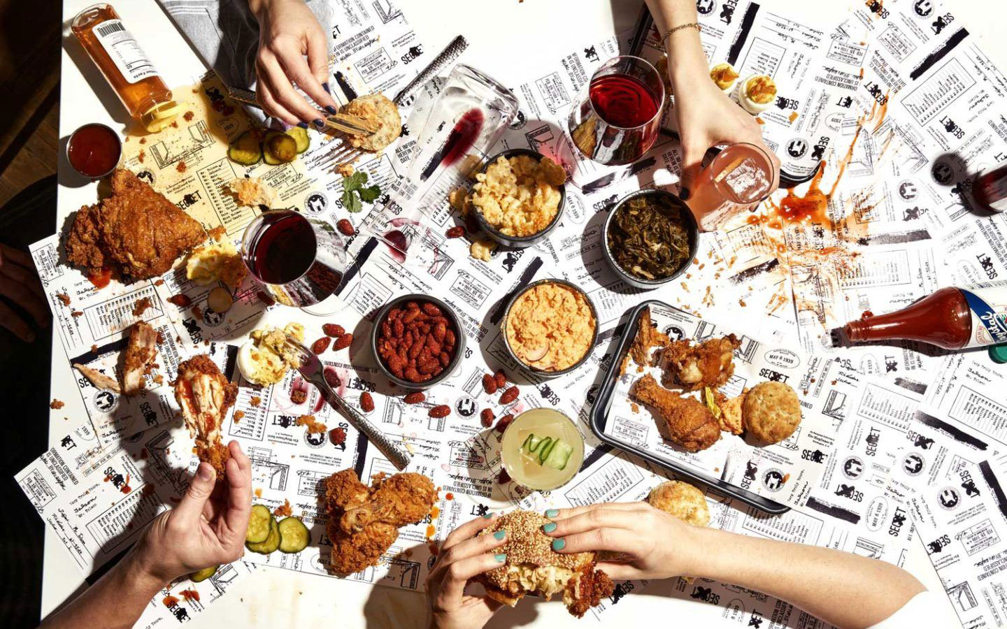 a group of people eating food on newspaper