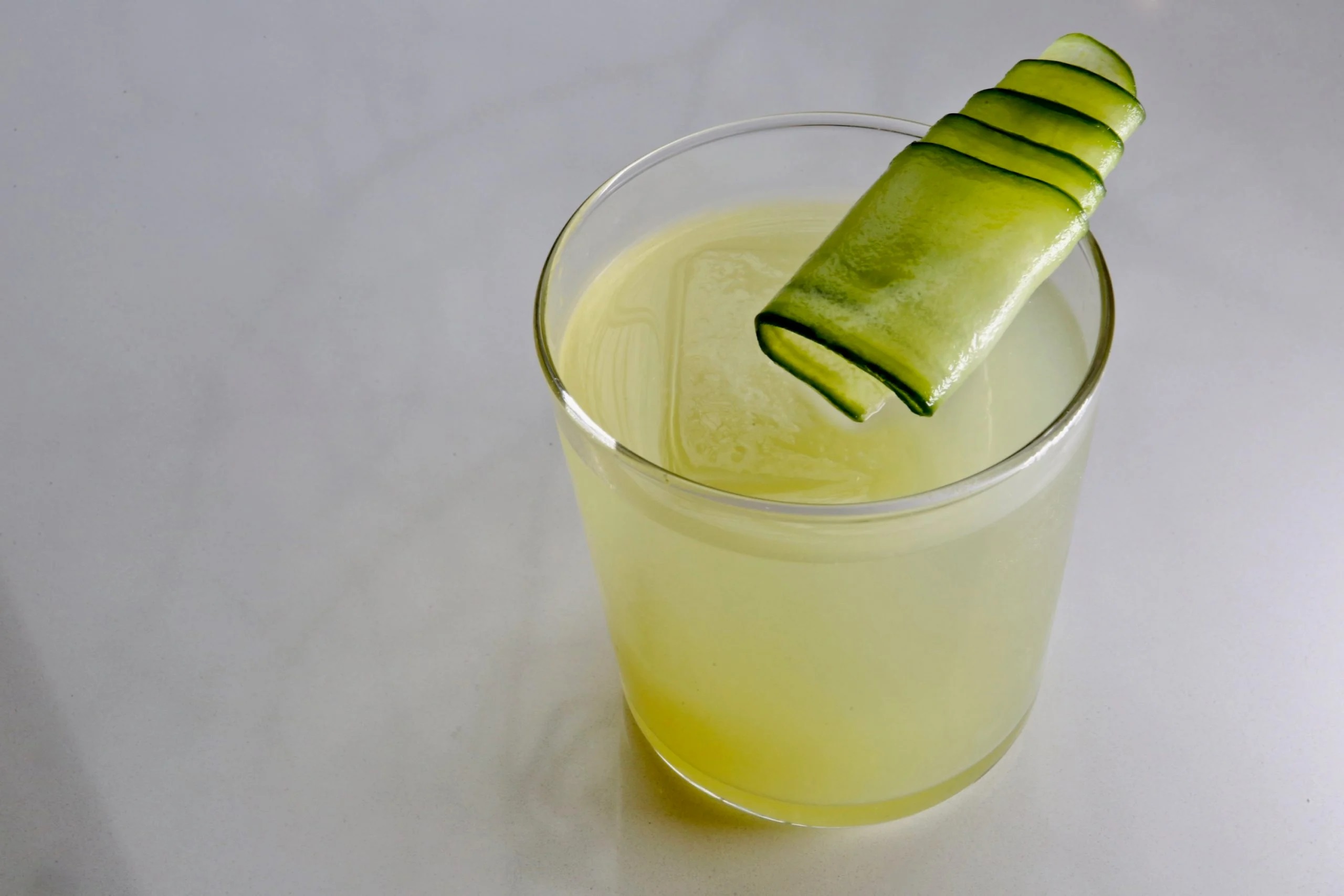 a cucumber slice in a glass of liquid