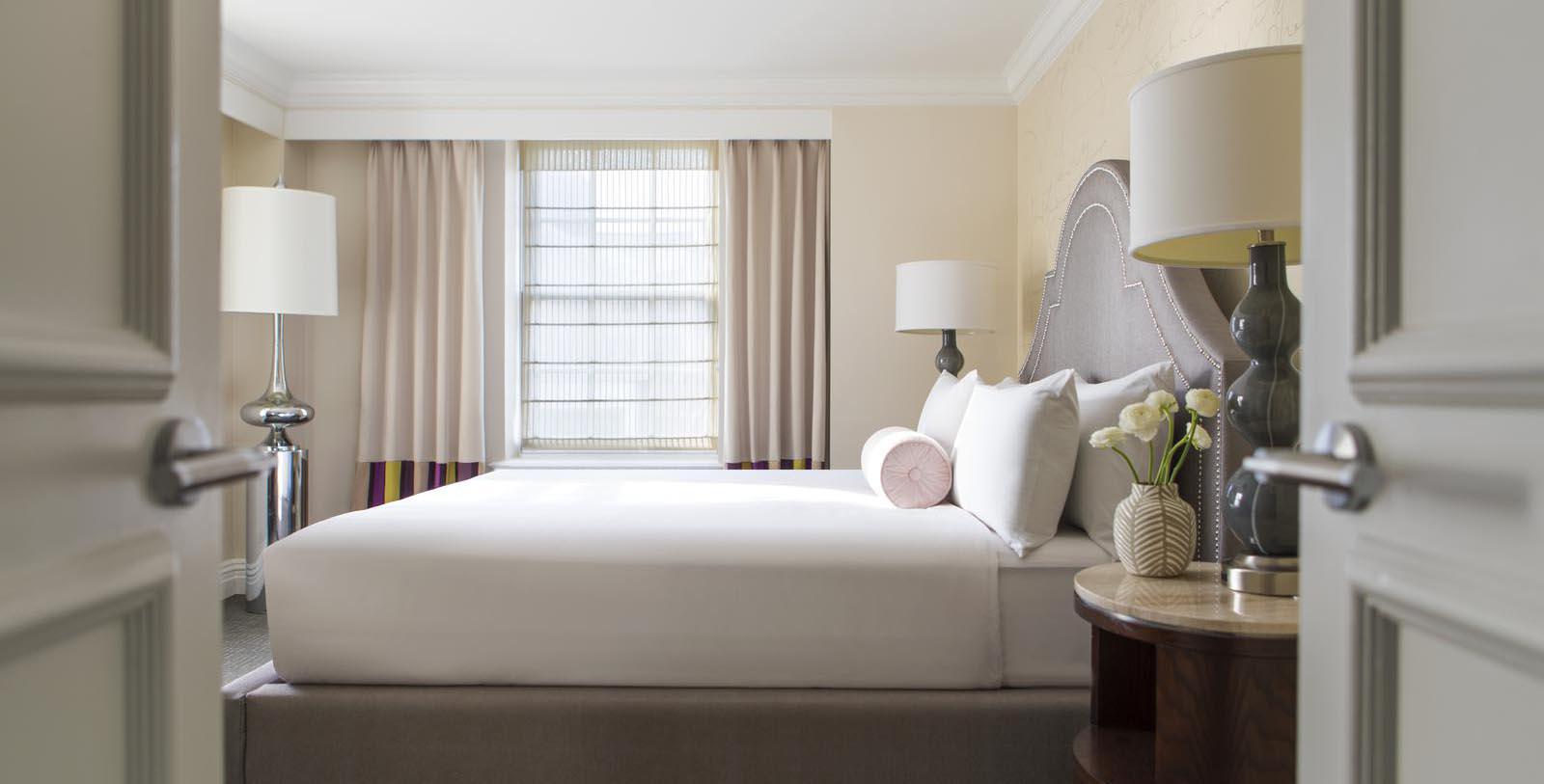 a bed with white sheets and a lamp