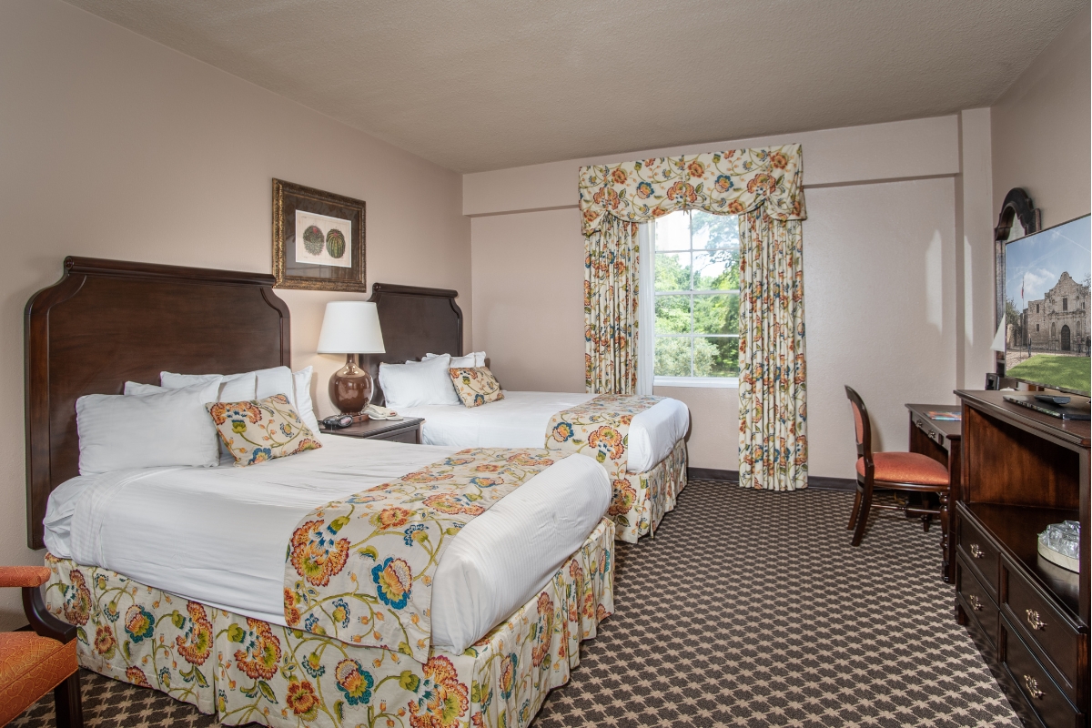 a room with two beds and a chair