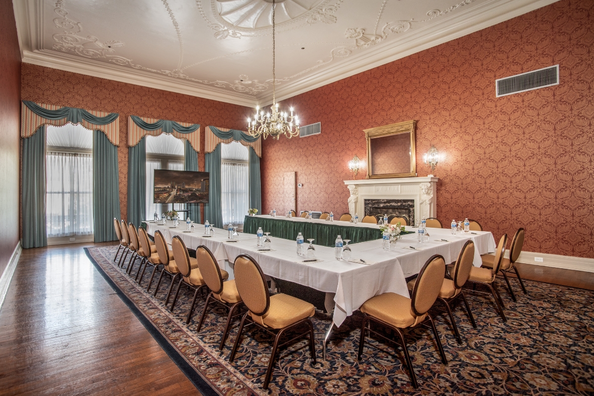 a long table set up in a room with chairs and a fireplace