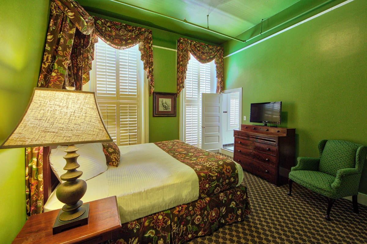 a bedroom with green walls and a bed and a lamp