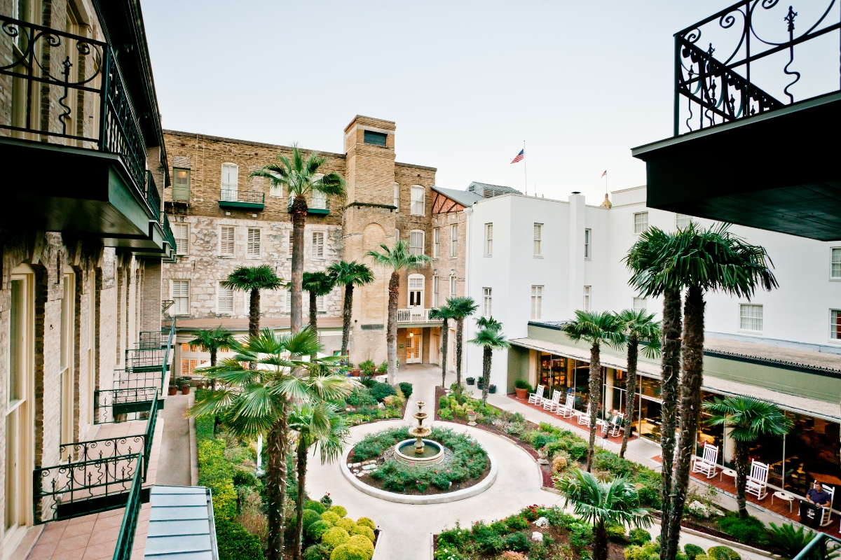 a courtyard with a fountain and palm trees