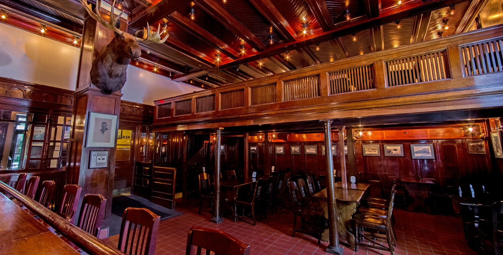 a room with a large moose head and a table and chairs