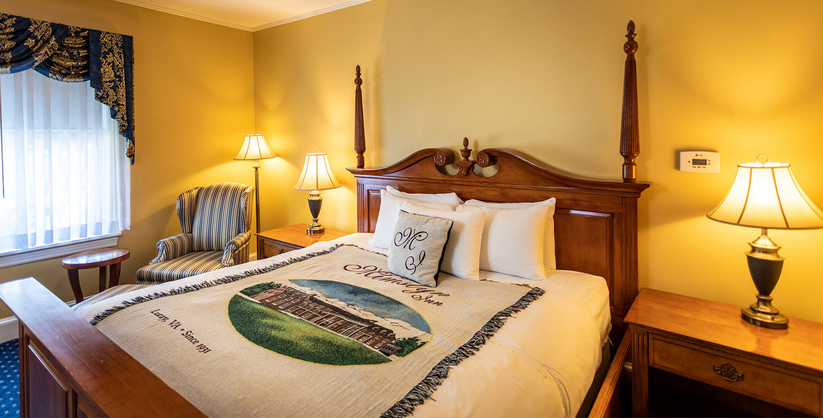 a bed with a blanket and lamp in a room