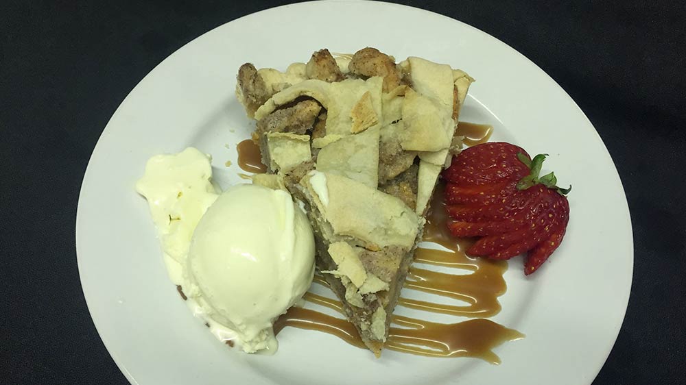 a plate of food with a slice of pie and ice cream