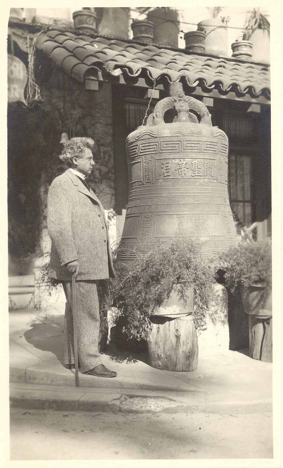 a man standing next to a large bell